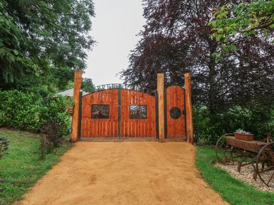 A wooden gate with plants and trees at Copper Suite in Chulmleigh