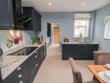 A kitchen with cabinets, sink, and dining table at 5 Station Avenue