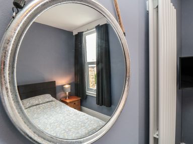 A bedroom with a bed and a mirror at 5 Station Avenue 