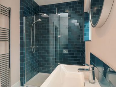 A bathroom with a shower, bathtub and mirror at 5 Station Avenue