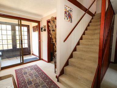 A hallway with a staircase and a front door at Dunvant in Swanage