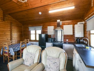 A kitchen with a table and chairs at Lodge 6 - Sleep 4 - Twin and Double in Criccieth