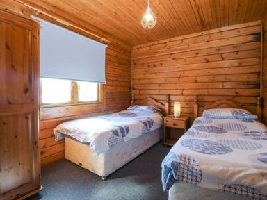 A bedroom with two single beds and a wardrobe at Lodge 6 - Sleep 4 - Twin and Double, Criccieth