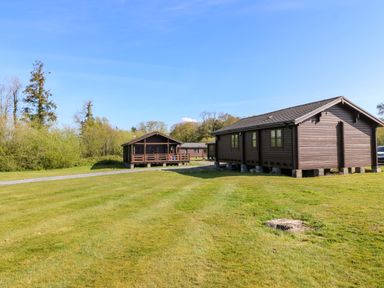 A view of log cabins and lawn at Lodge 6 - Sleep 4 - Twin and Double in Criccieth