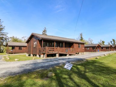 A cabin with a gravel path and trees at Lodge 6 - Sleep 4 - Twin and Double, Criccieth
