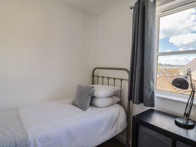 A bedroom with a single bed and lamp at 2 Lyme Mews in Seaton