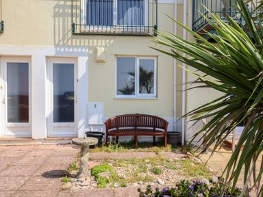 An outdoor area with a bench and fountain at 2 Lyme Mews in Seaton
