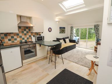 A kitchen with a gas stove and refrigerator at Juniper Hayloft in Ambleside