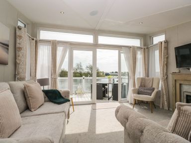 A living room with a view of the water at Swan Haven in Grange-Over-Sands