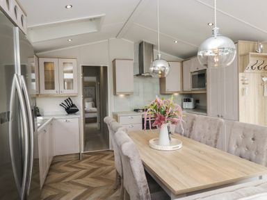 A kitchen with a dining area featuring a table and chairs at Swan Haven in Grange-Over-Sands