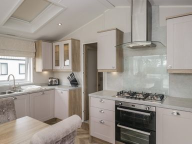 A kitchen with cabinets and appliances at Swan Haven in Grange-Over-Sands