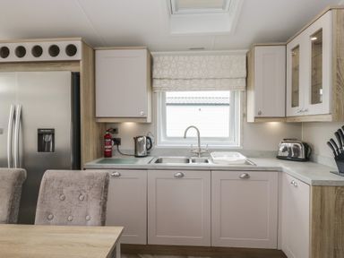 A kitchen with appliances and cabinets at Swan Haven in Grange-Over-Sands