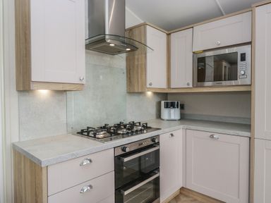 A kitchen with a gas stove and oven at Swan Haven in Grange-Over-Sands