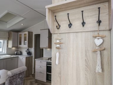 A kitchen with hooks and wooden shelf at Swan Haven in Grange-Over-Sands