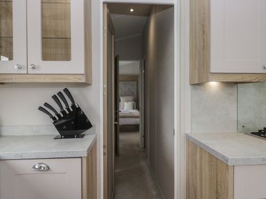 A kitchen with cabinets and a knife block at Swan Haven in Grange-Over-Sands