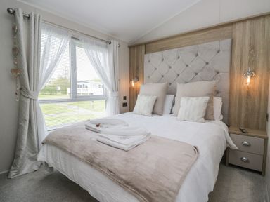 A bedroom with a bed and window at Swan Haven in Grange-Over-Sands