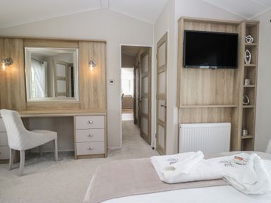 A bedroom with a desk and mirror at Swan Haven in Grange-Over-Sands