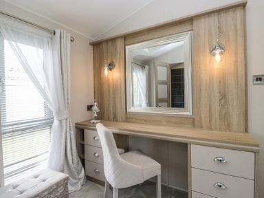 A dressing room with a desk and mirror at Swan Haven in Grange-Over-Sands