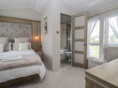 A bedroom with a bed and attached bathroom at Swan Haven in Grange-Over-Sands
