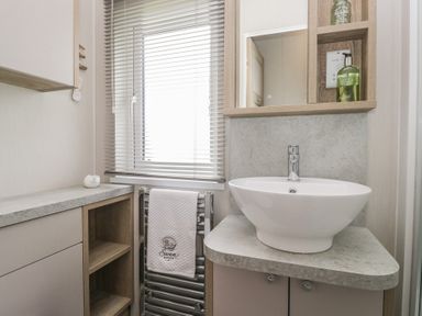 A bathroom with a sink and towel radiator at Swan Haven in Grange-Over-Sands