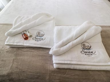 Towels and toiletries arranged on a bed at Swan Haven in Grange-Over-Sands