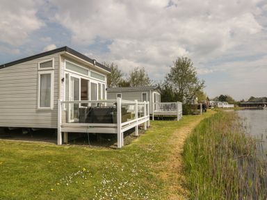 A house with a deck near water at Swan Haven in Grange-Over-Sands