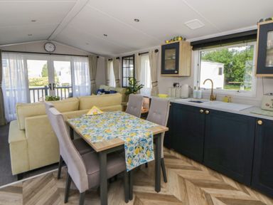 A living room with a dining table and sofa at Santa Maria in Llandysul