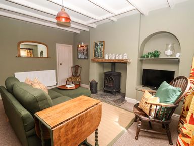 A living room with a sofa and a fireplace at The Cook’s Cottage in Malton