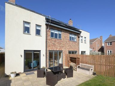 A garden with a patio and furniture at Beach Walk in Chathill