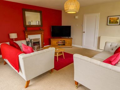 A living room with sofas and a television at Campden in Rennington near Embleton