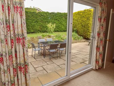 View of a patio with table and chairs from an indoor area at Campden in Rennington near Embleton