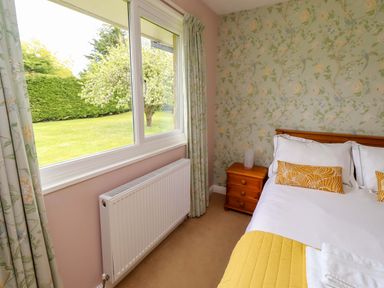 A bedroom with a bed and bedside table at Campden in Rennington near Embleton