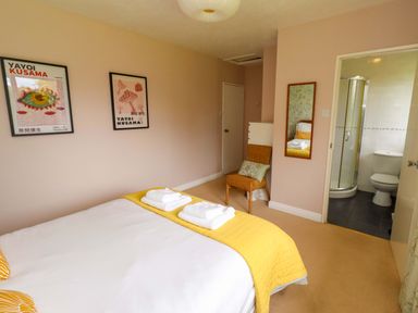 A bedroom with a bed and attached bathroom at Campden in Rennington near Embleton