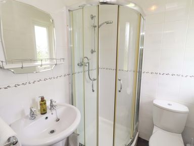 A bathroom with a shower, sink, and toilet at Campden in Rennington near Embleton