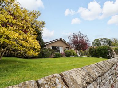 An exterior view of a house surrounded by a garden at Campden in Rennington near Embleton
