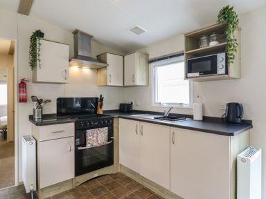 A kitchen with a cooker and sink at Forest Retreat - FO26 in Saxmundham