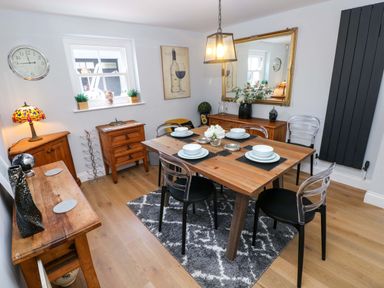 A dining room with a table set for dinner at Newgale Cottage in Haverfordwest