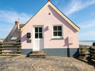 An exterior view of Newgale Cottage in Newgale with a door and window shown
