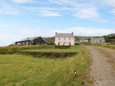 A house with grassy area and a pathway at Newgale Cottage in Newgale