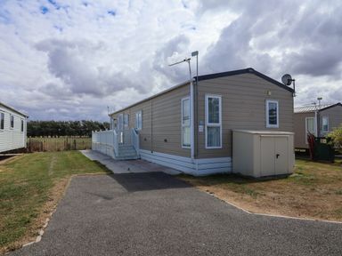 A caravan with steps and a satellite dish at Caravan i35 Towyn