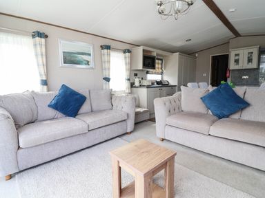 A living room with sofas and a coffee table at Caravan i35 Towyn