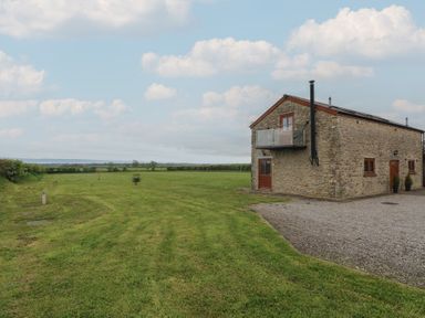 An outdoor area with a stone building and grass at The Gallops in Barry