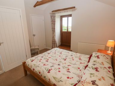 A bedroom with a bed and window at The Gallops in Barry