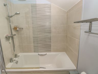 A bathroom with a shower over a bathtub at The Gallops in Barry