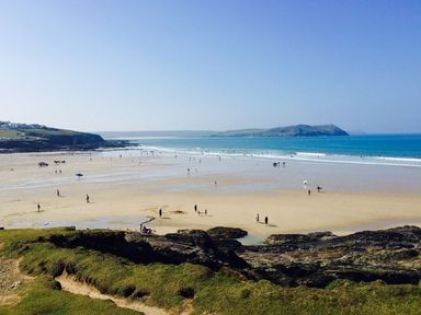 A beach view with people and ocean at Trehaverock Cottage in St. Endellion near Port Isaac