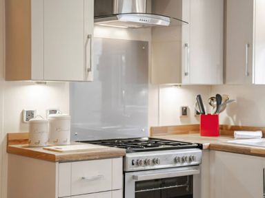 A kitchen with a stove and cabinets at Bingos Cabin in Holt