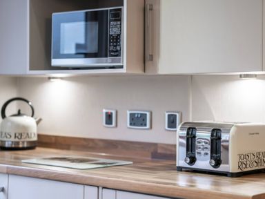 A kitchen with a microwave kettle and toaster at Bingos Cabin in Holt