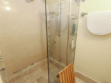 A shower with glass enclosure and showerhead at No 3 By The Sea in Weymouth