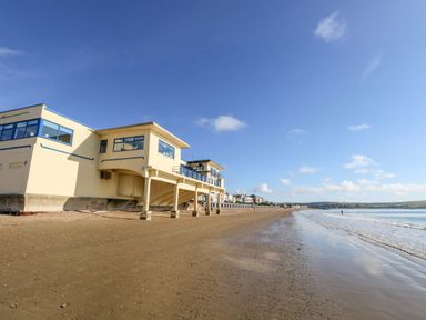 A beach with buildings beside it at No 3 By The Sea in Weymouth