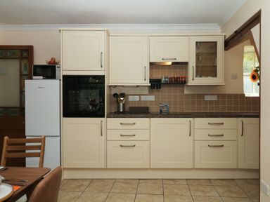 A kitchen with appliances and cabinets at Gorway Cottage in Teignmouth